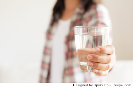 Eine Frau hält ein Wasserglas - Ist Aluminium in ihrem Trinkwasser ?